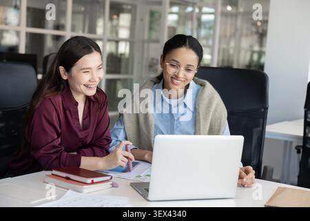 Diverse businesswomen looking at laptop screen Stock Photo