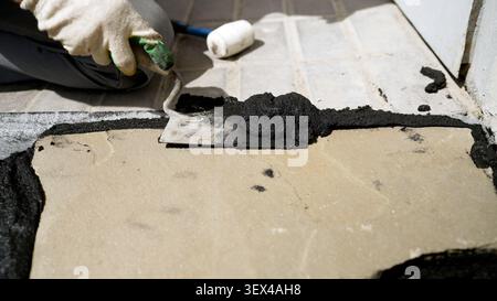Construction worker grouting irregular paving stones Stock Photo