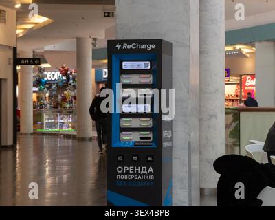 Kyiv, Ukraine - March 18, 2026: ReCharge battery kiosk provides automated power bank rentals in a busy retail center, allowing visitors to maintain mo Stock Photo