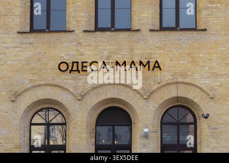 Kyiv, Ukraine - March 21, 2026: Black metallic lettering reading Odessa-Mama sits on a classic brick facade with decorative arched windows, highlighti Stock Photo