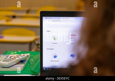 Kyiv, Ukraine - March 21, 2026: A person interacts with an educational website on a portable computer in a classroom, representing modern virtual lear Stock Photo