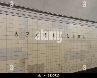 Kyiv, Ukraine - March 21, 2026: Gold letters on a tiled wall at the Arsenalna station display the transit hub name while highlighting its classical So Stock Photo