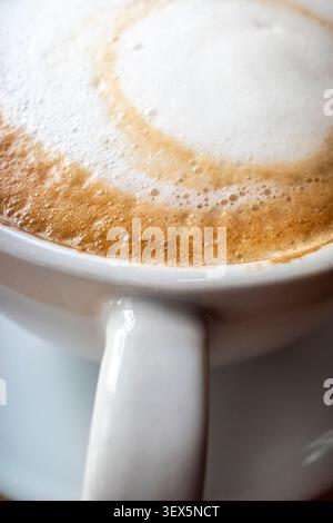 A closeup close up view of the froth on the surface of a flat white coffee. Stock Photo