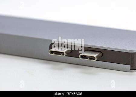 Macro close up view of two USB Type-C ports integrated into the side of a modern silver aluminum laptop computer showing detailed metallic connector p Stock Photo