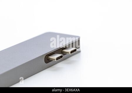 Close up of a modern silver aluminum USB type C hub adapter with two shiny metallic connectors isolated on a clean white background, showcasing premiu Stock Photo