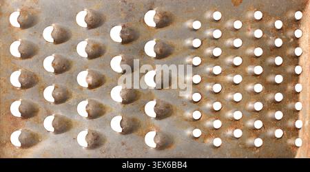 rusty metal grater surface texture, old distressed steel with sharp holes and brown rust spots, full frame closeup with copy space, vintage culinary Stock Photo