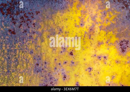 Abstract rusty metal background with vibrant yellow and purple weathered texture Stock Photo
