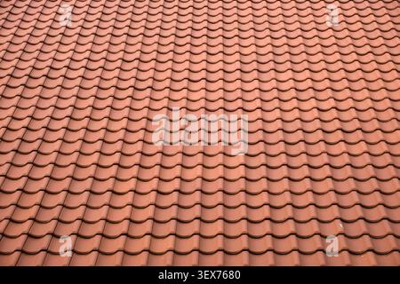 Texture and color of a traditional terracotta roof, highlighting its architectural design and repeating wave pattern Stock Photo