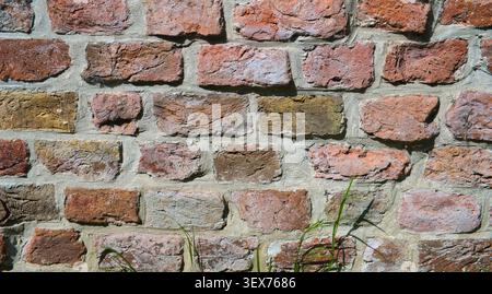 Close-up of an old, textured wall made of 11th-century bricks (in Dutch: kloostermoppen). Wall of a church in the north of the Netherlands Stock Photo