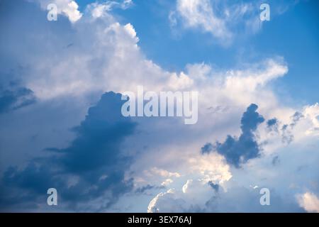 Dramatic sky with dark storm- and thunder clouds and bright sunlight breaking through Stock Photo