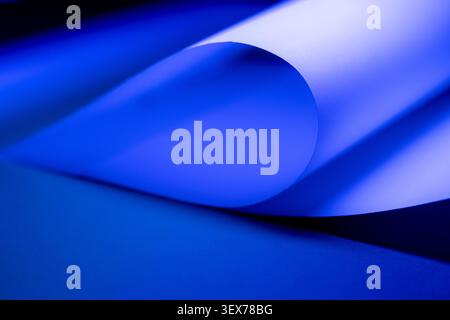 Blue iridescent paper creating a wavy abstract background with overlapping curves and soft shadows, ideal for modern design and technology concepts Stock Photo
