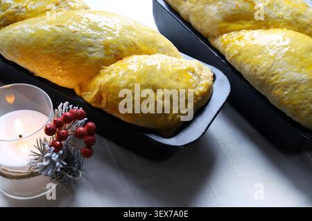 Traditional Romanian sweet bread cozonac baking in a loaf pan on Christmas holiday table setting. Christmas and holiday concept. Stock Photo