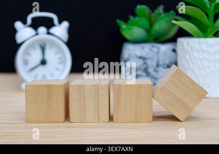 Wooden cube podium with vintage alarm clock and potted plant creating a modern natural product display setting Stock Photo