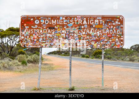 Australia, Western Australia, Balladonia, 90 Mile Straight Road sign covered with stickers, on the Eyre Highway in the Nullarbor Stock Photo