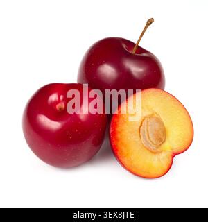 Ripe natural plums. In the foreground is half a plum. Plums on a white background. Stock Photo