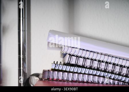 Close up of spiral notebooks on a metal shelf. Stock Photo