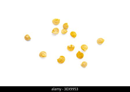 Pepper seeds scattered on a clean white background. Flat lay of yellow vegetable seeds isolated on white Stock Photo