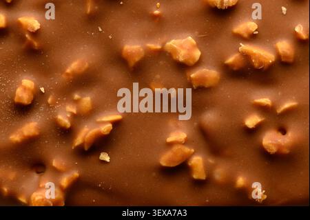 Chocolate candy with nuts no action present, in close-up of a chocolate surface, with chocolate, nuts, with chocolate, nut pieces texture, from a clos Stock Photo