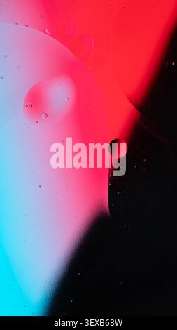 Oil and water creating abstract patterns, shapes, and colorful bubbles on a gradient background Stock Photo