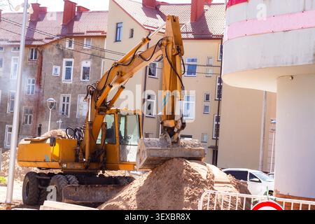 Construction workers preparing site before sidewalk paving. Urban construction scene. Developing city for new pedestrian paths Stock Photo