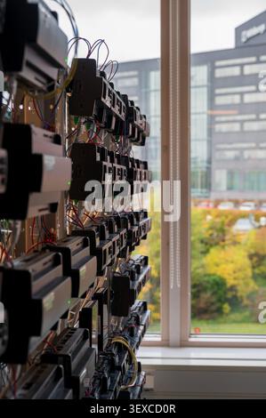 Server rack and network equipment mounted along a window in a tech facility Stock Photo