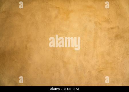 Earthy beige stucco wall surface showing rough natural texture plaster with subtle color gradient for background Stock Photo