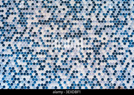 Closeup of decorative penny round ceramic mosaic tiles in various shades of blue and white forming abstract wave pattern on wall or floor surface Stock Photo