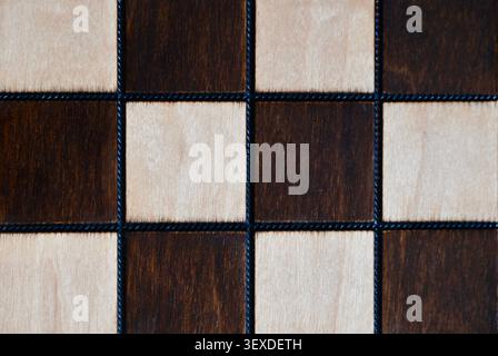 A minimalist, high-angle horizontal photograph capturing a clean texture of an empty wooden chessboard. Stock Photo