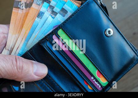 Hand Holding Black Leather Wallet with Euro Banknotes and Credit Cards, Finance and Banking Concept Stock Photo
