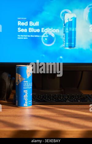 Tyumen, Russia-March 20, 2026: Blue Red Bull can on a gamer desk with a blurred computer screen, symbolizing the lifestyle of esports athletes Stock Photo