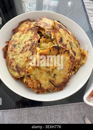 Homemade zucchini pancakes on white plate. Stock Photo
