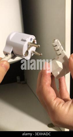 Broken European power plug in hands. Stock Photo
