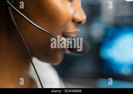 Administrator wears a headset in a server hub, using artificial intelligence troubleshooting to assist users. Stock Photo