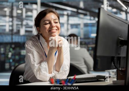 Cheerful data center technician celebrates improved system results in a data center after improved performance and completed server operations. Stock Photo