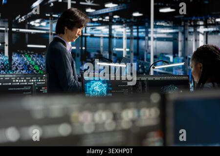 System administrators tune AI model settings on a computer workstation in a server farm to improve accuracy. Stock Photo