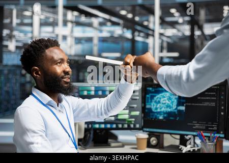 Data center engineer reviews artificial intelligence systems and machine learning processes inside a data center. Stock Photo