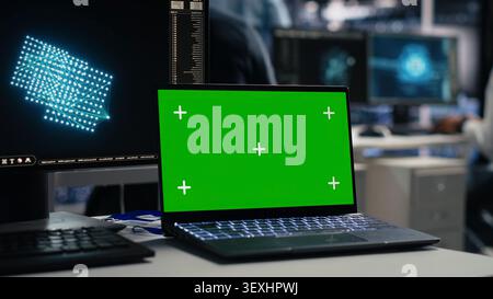 Software developer uses a green screen laptop to manage AI systems, machine learning workflows and server performance. Stock Photo