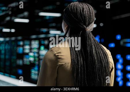 Data center engineer inspects server infrastructure, performs maintenance checks and reviews equipment diagnostics. Stock Photo