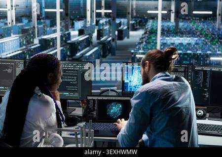 Woman works with a computer workstation in a server hub to support artificial intelligence systems. Stock Photo
