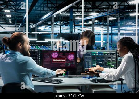 Team leader and software developers in computing hub work with deep learning to resolve hacking incident, while work with AI tech to stop exploits breaching security systems. Stock Photo