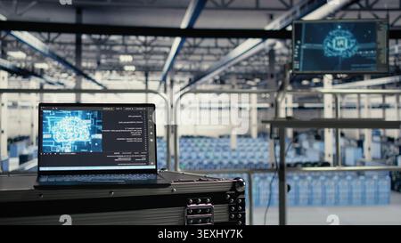 IT specialist works with a laptop in a industrial data center to support artificial intelligence systems. Stock Photo