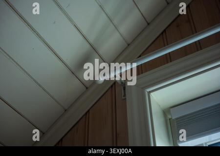 Clean modern ceiling design featuring white panels and metallic piping in a Lofoten building interior. Minimalist architectural detail with Stock Photo