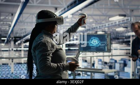 Software development team uses tablet-based deep learning tools in a server room to improve AI operations and system efficiency. Stock Photo