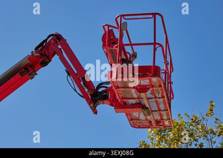 Extendable cherry picker with hydraulic arm and close up on cradle with safety rail. Stock Photo