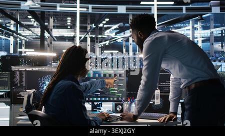 High tech server room team supervisor supervising technical specialist. Stock Photo