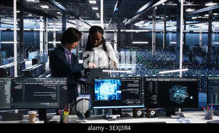 Multiethnic data center engineers review paperwork and use deep learning algorithms to analyze datasets and recognize patterns. Stock Photo