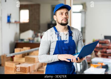 Contractor using laptop while working at construction site indoors Stock Photo