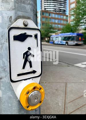 Pedestrian crosswalk button and walk-symbol sign on a busy urban street in Vancouver, Canada. Stock Photo