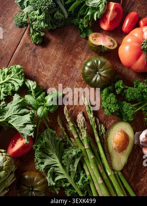 Various fresh vegetables and herbs on a wooden surface Stock Photo