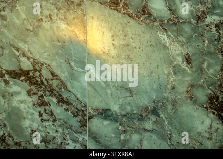 High-angle close-up of a luxurious Verde Smeralda quartzite slab from Bahia, Brazil, featuring a vibrant emerald green mineral base with intricate nat Stock Photo